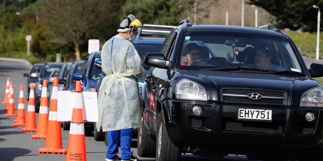 Medical staff prepare to take a COVID-19 test from a visitor to a drive-through community-based assessment center in Christchurch, New Zealand, on Aug. 13, 2020. (AP Photo/Mark Baker)