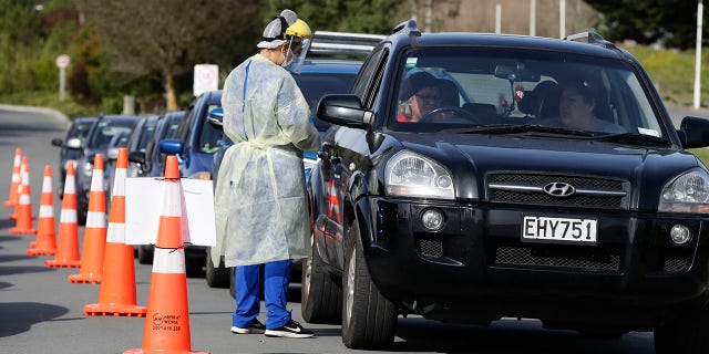 Métis - Medical staff prepare to take a COVID-19 test from a visitor to a drive-through community-based assessment center in Christchurch, New Zealand, on Aug. 13, 2020. (AP Photo/Mark Baker)