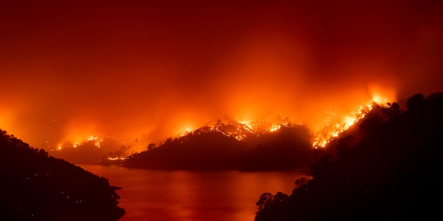 Flames from the LNU Lightning Complex fires burn around Lake Berryessa in unincorporated Napa County, Calif., on Wednesday, Aug. 19, 2020.