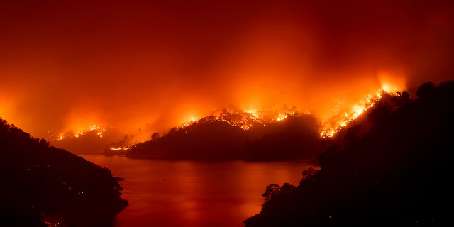 Flames from the LNU Lightning Complex fires burn around Lake Berryessa in unincorporated Napa County, Calif., on Wednesday, Aug. 19, 2020.