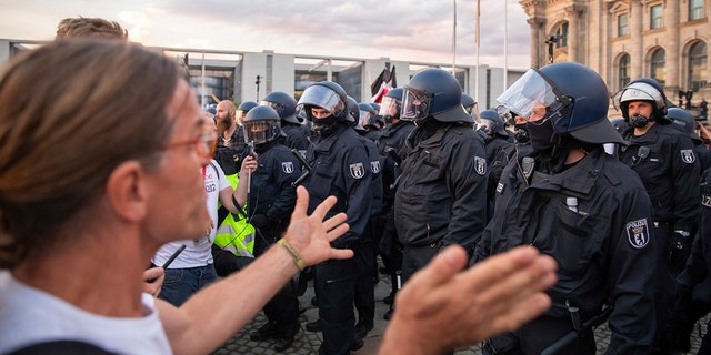 Police officers push away a crowd of demonstrators from the square 'Platz der Republik' in front of the Reichstag building during a demonstration against the Corona measures in Berlin, Germany, Saturday, Aug. 29, 2020. (Christoph Soeder/dpa via AP)
