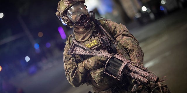 A federal officer holds a tear gas rifle during a Black Lives Matter protest at the Mark O. Hatfield U.S. Courthouse in Portland, Ore. (AP Photo/Marcio Jose Sanchez)