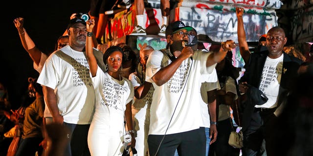 Philonise Floyd, brother of George Floyd, second from right, gestures as he addresses a crowd in front of the statue of Confederate General Robert E. Lee on Monument Avenue on Tuesday July 28, 2020, in Richmond, Va. (AP Photo/Steve Helber)