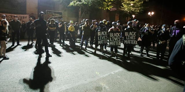 A crowd gathers during a Black Lives Matter protest at the Mark O. Hatfield United States Courthouse Thursday, July 30, 2020, in Portland, Ore. After days of clashes with federal police, the crowd outside of the federal courthouse remained peaceful Thursday night. (AP Photo/Marcio Jose Sanchez)