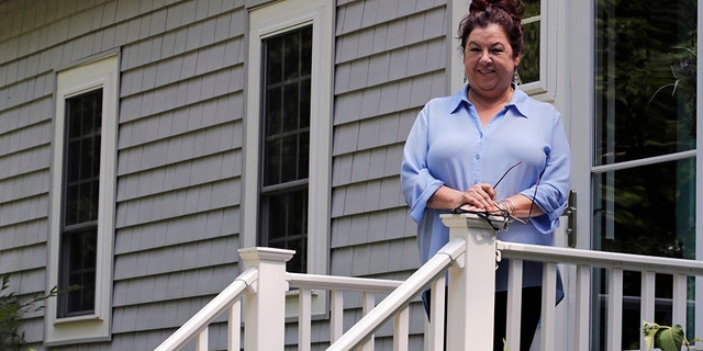 Poet Tammi Truax poses, Wednesday, July 29, 2020, on the front steps of her home in Eliot, Maine. Truax, the poet laureate for Portsmouth, N.H., pens a weekly pandemic poem that is included in the city's COVID-19 newsletter. (AP Photo/Charles Krupa)