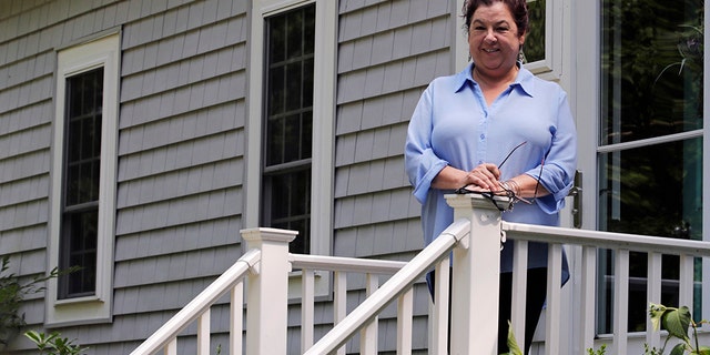 Poet Tammi Truax poses, Wednesday, July 29, 2020, on the front steps of her home in Eliot, Maine. Truax, the poet laureate for Portsmouth, N.H., pens a weekly pandemic poem that is included in the city's COVID-19 newsletter. (AP Photo/Charles Krupa)