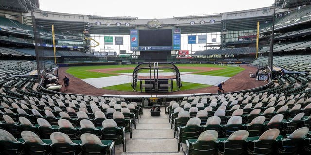 FILE - In this Friday, July 31, 2020, file photo, fan cutouts sit in seats behind home plate at Miller Park after it was announced that the baseball game between the Milwaukee Brewers and Cardinals in Milwaukee, was postponed after two Cardinals employees tested positive for the coronavirus. One more player and three staff members with the Cardinals have tested positive for the coronavirus, leading to the postponement of their game on Saturday against the Brewers, according to a person familiar with the situation. (AP Photo/Morry Gash, File)