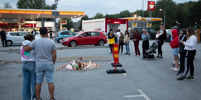 Flowers and candles are placed Sunday Aug. 2, 2020 near where a twelve-year-old girl was shot and killed near a petrol station in Botkyrka, south of Stockholm, Sweden. (Ali Lorestani//TT via AP)