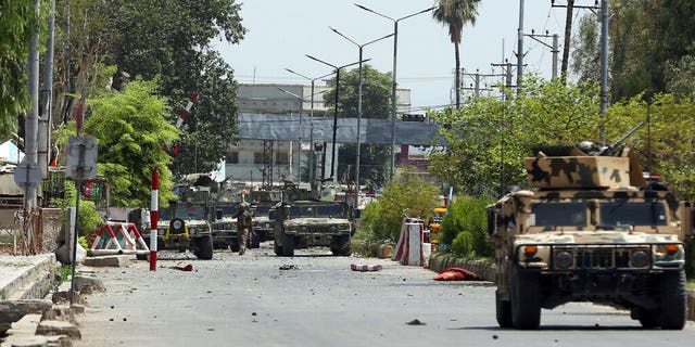 Afghan security personnel gather in front of a prison after an attack in the city of Jalalabad, east of Kabul, Afghanistan, Monday, Aug. 3, 2020. An Islamic State group attack on the prison in eastern Afghanistan holding hundreds of its members raged on Monday after killing people in fighting overnight, a local official said.