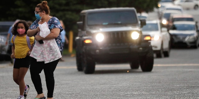 Students arrive to Dallas Elementary School for the first day of school amid the coronavirus outbreak on Monday, Aug. 3, 2020, in Dallas, Ga. (AP Photo/Brynn Anderson)