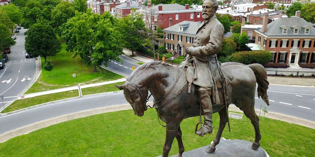 A statue of Confederate General Robert E. Lee standing in the middle of a traffic circle on Monument Avenue in Richmond, Va.