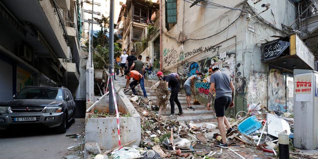 People clean up after a massive explosion in Beirut, Lebanon, Wednesday, Aug. 5, 2020. 