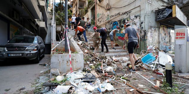 People clean up after a massive explosion in Beirut, Lebanon, Wednesday, Aug. 5, 2020.