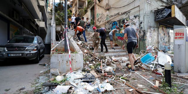 People clean up after a massive explosion in Beirut, Lebanon, Wednesday, Aug. 5, 2020. 