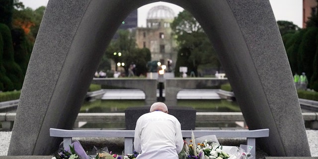 A man prays in front of the cenotaph for the atomic bombing victims before the start of ceremony to mark the 75th anniversary of the bombing in Hiroshima, western Japan, early Thursday, Aug. 6, 2020. (AP Photo/Eugene Hoshiko)