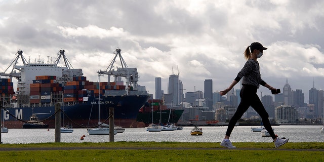 A woman takes a walk in a park during lockdown due to the continuing spread of the coronavirus in Melbourne on Aug. 6. Victoria state, Australia's coronavirus hot spot, announced last week that businesses will be closed and scaled down in a bid to curb the spread of the virus. (AP Photo/Andy Brownbill)