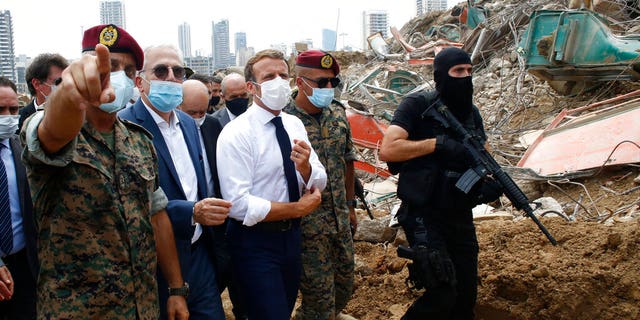 French President Emmanuel Macron, center, visits the site of the explosion at the port of Beirut, Lebanon on Thursday, Aug. 6. (AP Photo/Thibault Camus, Pool)