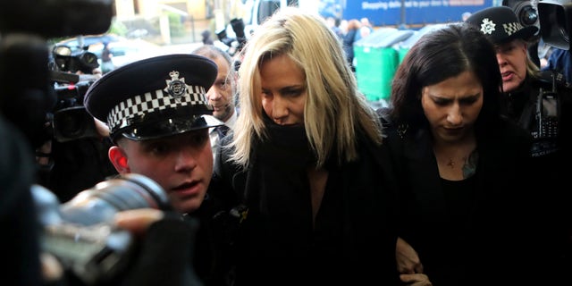 In this Dec. 23, 2019 photo, 'Love Island' TV presenter Caroline Flack (center) as she arrives at Highbury Magistrates' Court in London. A British coroner has ruled Thursday Aug. 6, 2020, that reality TV host Caroline Flack killed herself while facing an assault trial she feared would end her career and bring unbearable media scrutiny. (AP Photo/Petros Karadjias, FILE)