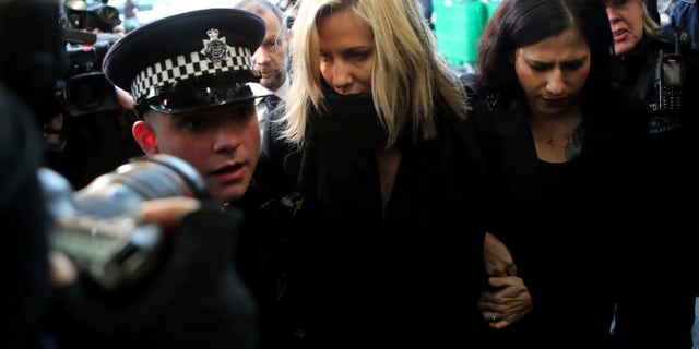 In this Dec. 23, 2019 photo, 'Love Island' TV presenter Caroline Flack (center) as she arrives at Highbury Magistrates' Court in London. A British coroner has ruled Thursday Aug. 6, 2020, that reality TV host Caroline Flack killed herself while facing an assault trial she feared would end her career and bring unbearable media scrutiny. (AP Photo/Petros Karadjias, FILE)