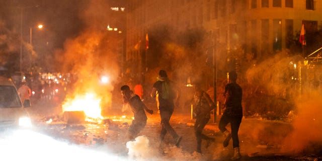 Riot police fire tear gas at anti-government protesters in Beirut, Lebanon, on Friday, Aug. 7, 2020. (AP Photo/Hassan Ammar)