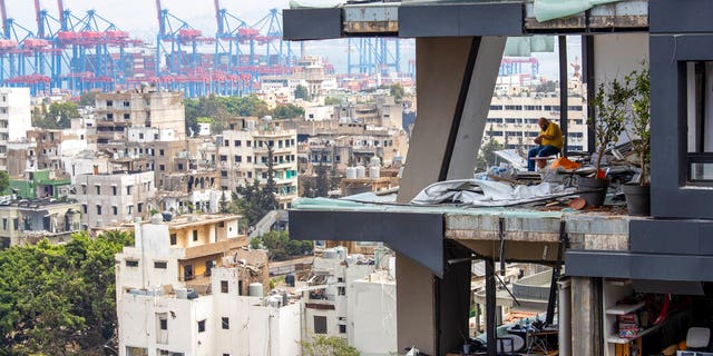 A man sits among debris inside his house damaged by Tuesday's explosion in the seaport of Beirut, Lebanon. (AP Photo/Hassan Ammar)