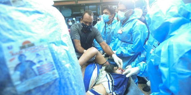 One of the injured after an Air India Express flight skidded off a runway while landing at the Kozhikode airport is brought for treatment to the Medical College Hospital in Kozhikode, Kerala state, India. (AP Photo)
