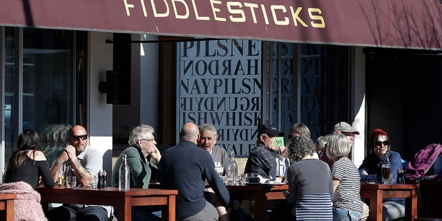 Customers at a cafe enjoy lunch in the sunshine in Christchurch, New Zealand, Sunday, Aug. 9, 2020. (AP Photo/Mark Baker)