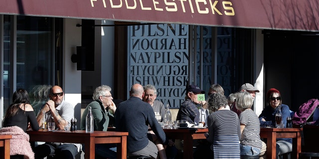 Customers at a cafe enjoy lunch in the sunshine in Christchurch, New Zealand, Sunday, Aug. 9, 2020. (AP Photo/Mark Baker)