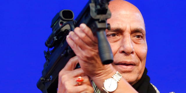 FILE- In the February 7, 2020 file photo, Indian Defense Minister Rajnath Singh holds a model of a light machine gun during the DefExpo20 event in Lucknow, India. Mr. Singh said India would ban the import of 101 military equipment items in an effort to boost indigenous production and enhance self-reliance in weapon production. (AP Photo / Rajesh Kumar Singh, File)