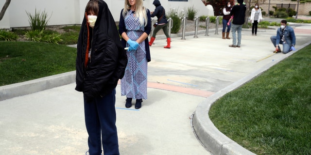 Worshipers line up to take communion on Palm Sunday outside of Godspeak Calvary Chapel in Newbury Park, Calif on April 5, 2020. (AP Photo/Marcio Jose Sanchez, File)