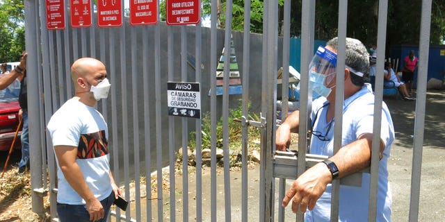 An electoral official, right, tells a voter that the ballots haven't arrived at a voting center in Carolina, Puerto Rico, Sunday, Aug. 9, 2020. Puerto Rico's primaries were marred on Sunday by a lack of ballots in a majority of centers across the U.S. territory, forcing frustrated voters who braved a spike in COVID-19 cases to turn around and go back home. 