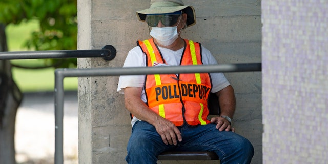 A worker waiting outside the polling place during early primary voting at the Miami Dade College North Campus in Miami on Aug. 9.