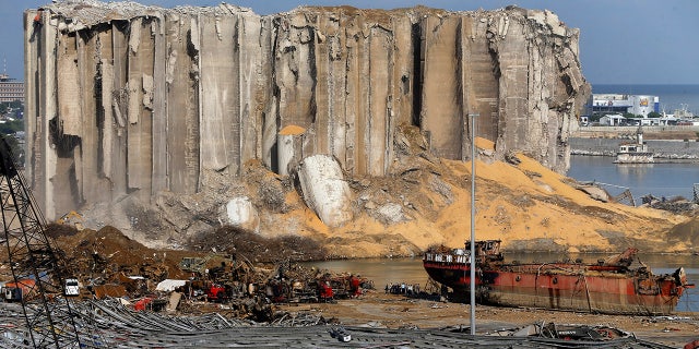 Earthmoving equipment and rescue workers search for victims, Monday, Aug. 10, 2020, in Beirut, Lebanon, near the site of last week's explosion that hit the city's seaport. (AP Photo/Bilal Hussein)