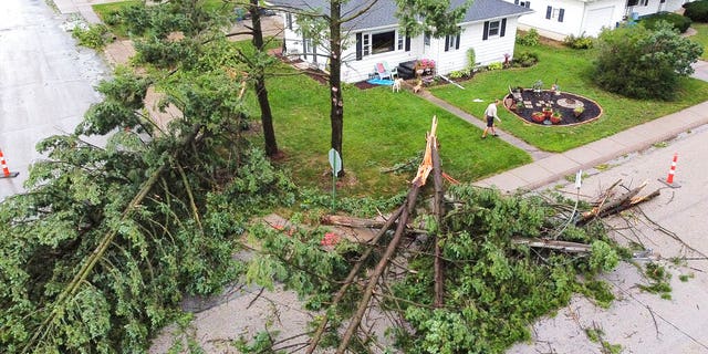 Downed trees and a utility pole in front of the home of Tim and Patricia Terres in Walcott, Iowa after high winds and heavy rain passed through the area Monday, Aug. 10, 2020, in Davenport, Iowa.