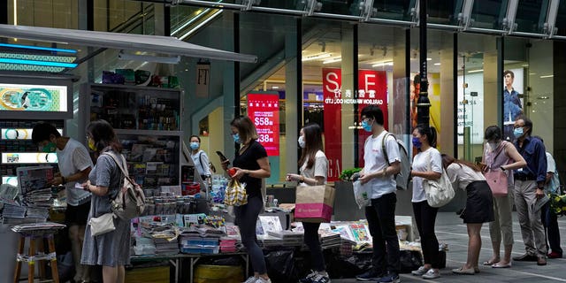 People lined up at the newsstand to buy copies of Apple Daily in a central street in Hong Kong on Tuesday, August 11, 2020, as an endorsement, a day after founder Jimmy Lai was arrested.