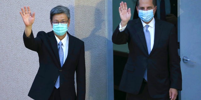 Azar and Taiwan former Vice President Chen Chien-jen wave before Azar delivers a speech at National Taiwan University College of Public Health in Taipei, Taiwan Tuesday, Aug. 11, 2020. (AP Photo/Chiang Ying-ying)