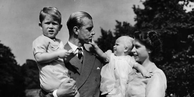 FILE - In this Aug. 1951 file photo, Britain's Queen Elizabeth II, then Princess Elizabeth, stands with her husband Prince Philip, the Duke of Edinburgh, and their children Prince Charles and Princess Anne at Clarence House, the royal couple's London residence. (AP Photo/Eddie Worth, File)