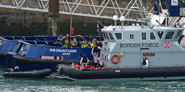 A group of people thought to be migrants are brought into Dover, England, Wednesday, Aug. 12, 2020, by Border Force officers. (Kirsty O'Connor/PA via AP)