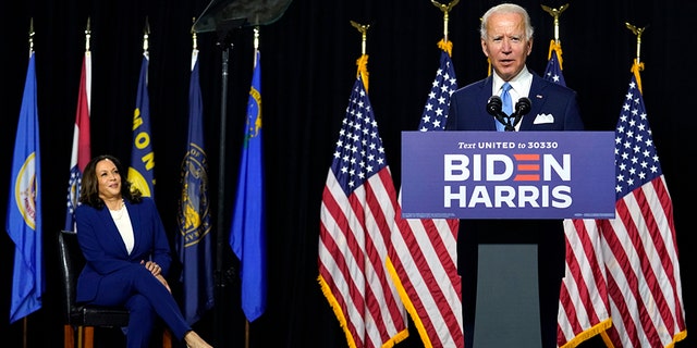Democratic presidential candidate former Vice President Joe Biden speaks as his running mate Sen. Kamala Harris, D-Calif., listens during a news conference at Alexis Dupont High School in Wilmington, Del., Wednesday, Aug. 12, 2020. (AP Photo/Carolyn Kaster)