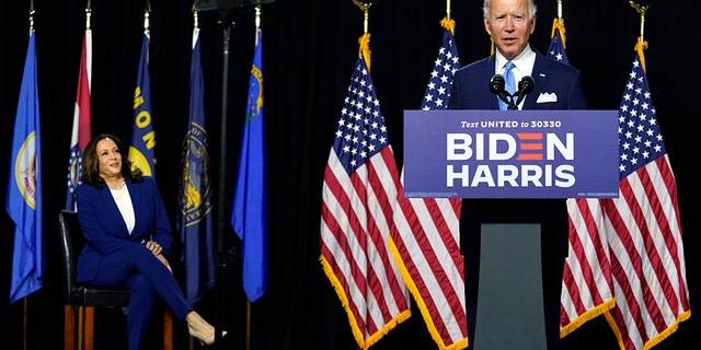 Democratic presidential candidate former Vice President Joe Biden speaks as his running mate Sen. Kamala Harris, D-Calif., listens during a news conference at Alexis Dupont High School in Wilmington, Del., Wednesday, Aug. 12, 2020. (AP Photo/Carolyn Kaster)