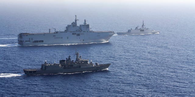 In this photo provided by the Greek National Defence, a French Tonnerre helicopter carrier, rear left is escorted by Greek and French military vessels during a maritime exercise in the Eastern Mediterranean, Thursday, Aug. 13, 2020. 