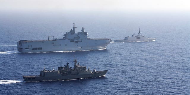 In this photo provided by the Greek National Defense, a French helicopter carrier Tonnerre, the rear left is accompanied by Greek and French military ships during a naval exercise in the Eastern Mediterranean, Thursday, August 13, 2020.