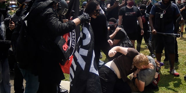 A melee breaks out during a protest, Aug. 15, in Stone Mountain Village, Ga. (AP Photo/Mike Stewart)