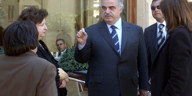 FILE - In this Feb. 14, 2005 file photo, former Lebanese Prime Minister Rafik Hariri, center, speaks to people outside the Lebanese Parliament minutes before an explosion killed him and 22 others, in Beirut, Lebanon. More than 15 years after the truck bomb assassination of Hariri in Beirut, a U.N.-backed tribunal in the Netherlands is announcing verdicts this week in the trial of four members of the militant group Hezbollah allegedly involved in the killing. (AP Photo, File)