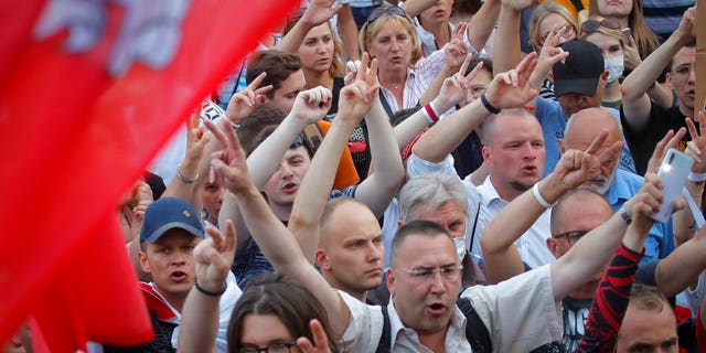 Belarusian opposition supporters shout slogans during a protest rally in front of the government building at Independent Square in Minsk, Belarus, Tuesday, Aug. 18, 2020.