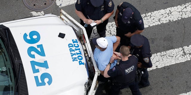 New York City police officers detain and question a man in the Bronx borough of New York. Many NYPD officers are being told to change their work shifts to be available on weekends in an effort to address the growing violence in the city. (AP Photo/Mark Lennihan, File)