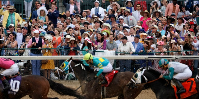 FILE - In this May 4, 2019, file photo, fans cheer as they watch a race at Churchill Downs before the 145th running of the Kentucky Derby horse race in Louisville, Ky. (AP Photo/John Minchillo, File)