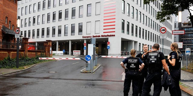German police officers stand in front of the emergency entrance of the Charite hospital where Alexei Navalny is expected to arrive in Berlin, Germany, Saturday, Aug.22, 2020. The dissident who is in a coma after a suspected poisoning has been transferred from the Siberian city of Omsk. Navalny is flown to Germany to receive treatment. (AP Photo/Markus Schreiber)