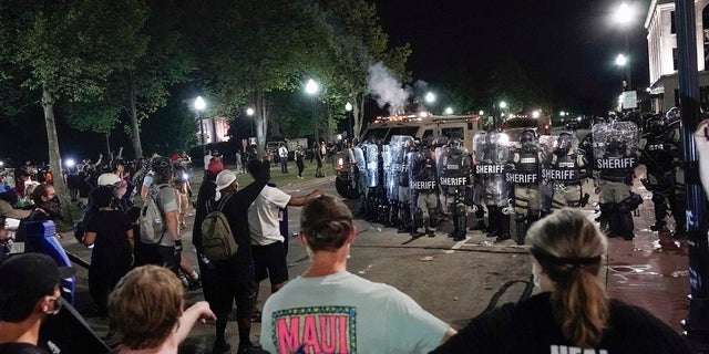 Police clash with protesters near the Kenosha County Courthouse, Monday, Aug. 24, 2020, in Kenosha, Wis. (AP Photo/Morry Gash)