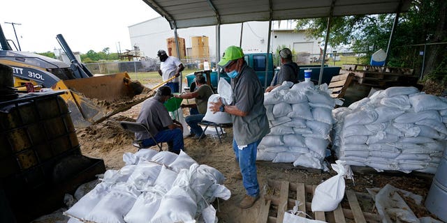 Municipal workers fill sandbags for the elderly and those with disabilities ahead of Hurricane Laura in Crowley, La., Tuesday, Aug. 25, 2020. (AP Photo/Gerald Herbert)